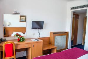 a hotel room with a bed, desk and television at Hotel Petka in Dubrovnik