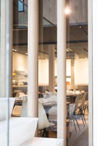 a dining room with white tables and chairs at Hotel Den Berg in Londerzeel