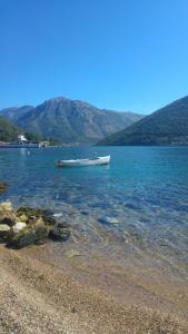 a boat in the water next to a beach at Apartment Glorija in Kamenari