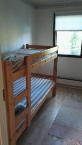 a wooden bunk bed in a room with a window at Huvikumpu in Orivesi