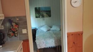 a bedroom with a bed and a clock on the wall at Huvikumpu in Orivesi