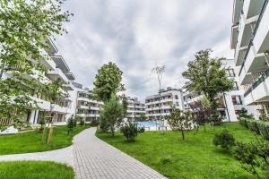 a walkway through a park with apartment buildings at Apartament Crystal in Ustronie Morskie