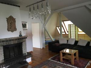 ein Wohnzimmer mit einem schwarzen Sofa und einem Kamin in der Unterkunft Kunsthaus Kurgan in Potsdam