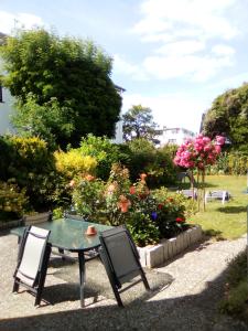 einen Tisch und Stühle in einem Garten mit Blumen in der Unterkunft Fewo Am Deich mit Garten, 70m zum Strand, Fahrradgarage in Dahme
