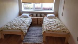 2 camas en una habitación pequeña con ventana en Järva Jahindusklubi HOSTEL, en Paide