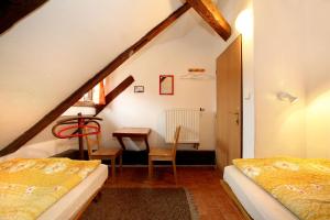 a attic room with two beds and a table at Hostel Merlin in Český Krumlov