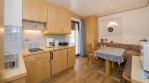 a kitchen with wooden cabinets and a table in it at Landhaus Relly in Seefeld in Tirol