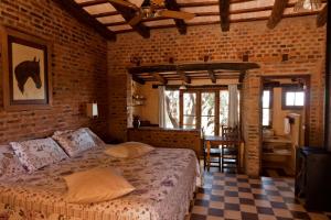 a bedroom with a bed in a brick wall at LAS JARILLAS Hostería & Bodega in San Javier