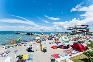 a beach with a crowd of people and the water at Rooms Neda in Izola