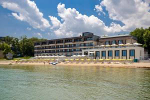 a building on the shore of a body of water at Nympha Hotel, Riviera Holiday Club - All Inclusive & Private Beach in Golden Sands