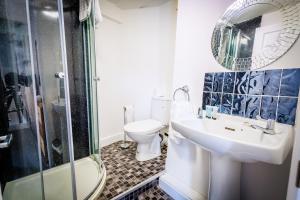 a bathroom with a toilet and a sink and a shower at Dunraven Hotel in Rhondda