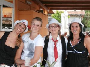 Tres mujeres con sombreros blancos posando para una foto en Hotel Caravel, en Marotta