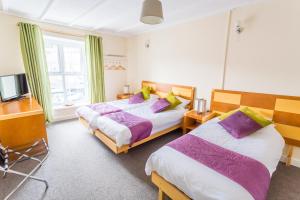 um quarto com duas camas e uma televisão em Dunraven Hotel em Rhondda