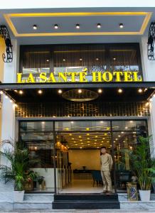 un hombre parado frente a un restaurante en La Santé Hotel & Spa, en Hanói