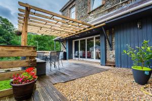 an outdoor deck with a pergola and patio at Dunraven Hotel in Rhondda