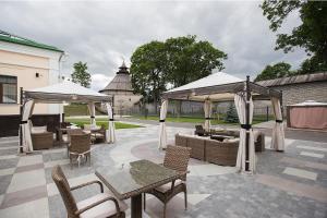 un patio con ombrelloni, tavoli e sedie di Hotel Pokrovsky a Pskov