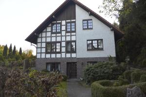 a white and black house with a driveway at Wiehen Inn in Heddinghausen