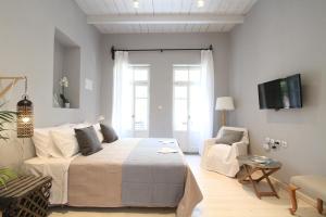 a bedroom with a bed and a couch and a tv at Fagotto Art Residences in Chania Town