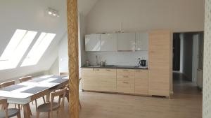 Una cocina con gabinetes blancos y una mesa con sillas. en Apartamenty Marina by Manage Rent, en Ustka