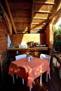 a table and chairs on a porch with a kitchen at Addo Dung Beetle Guest Farm in Addo