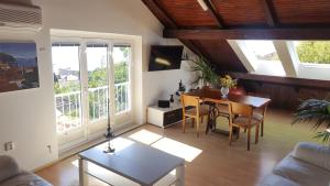 - un salon avec une table, des chaises et des fenêtres dans l'établissement Turtle Apartments, à Dubrovnik