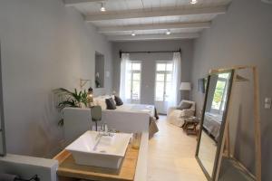 a bathroom with a sink and a living room at Fagotto Art Residences in Chania Town