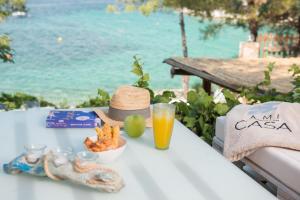 a table with a hat and a bowl of food and a drink at Amicasa Private Seaside Suite in Pachis