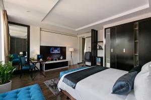 a bedroom with a king sized bed and a desk at La Santé Hotel & Spa in Hanoi