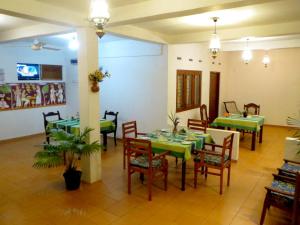 un comedor con mesas verdes y sillas en C-Lanka Guest House en Aluthgama