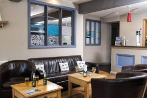 a restaurant with leather chairs and a table with wine glasses at The Ship Hotel in Aberdaron