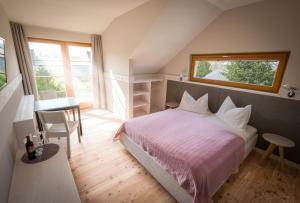 una camera da letto con un letto, un tavolo e una finestra di SCHEIBER Wein & Gästehaus a Weiden am See