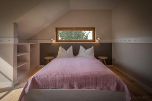 a bedroom with a large bed with a window at SCHEIBER Wein & Gästehaus in Weiden am See