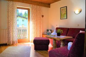 a living room with a couch and a table and a window at Haus Hoher Sattel in Leutasch