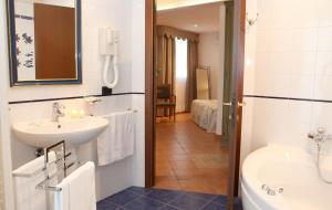 uma casa de banho com um lavatório, um WC e uma banheira em Hotel Plaza em Lido degli Estensi