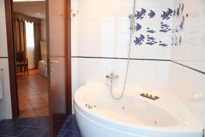 uma banheira na casa de banho com azulejos azuis e brancos em Hotel Plaza em Lido degli Estensi