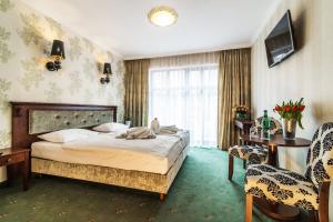 pokój hotelowy z łóżkiem i krzesłem w obiekcie Pałac Margot Nature&SPA w mieście Karpacz