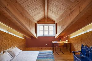 a bedroom with a bed and a desk and a window at Fence Houses in Coimbra