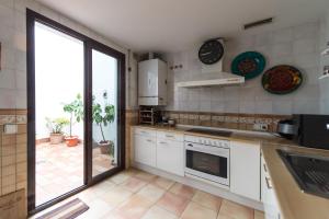 eine Küche mit weißen Geräten und einem großen Fenster in der Unterkunft El Mirador Altos de Santa Ana in Córdoba