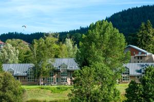 un edificio en las montañas con árboles en el primer plano en VTF Le Bief Rouge, en Métabief