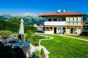 ein Haus mit Rasen und Regenschirm in der Unterkunft Alberts Bellevue Appartements in Nauders