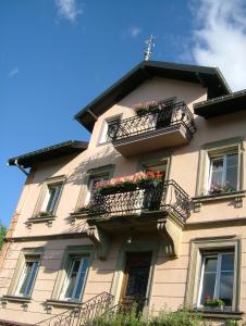 un edificio alto con balcones y flores. en chambres d'hotes " Le Magnolia ", en Sainte-Croix-aux-Mines