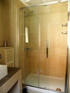 a shower with a glass door in a bathroom at Honfleur de lys in Honfleur