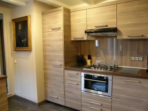 a kitchen with wooden cabinets and a stove top oven at Honfleur de lys in Honfleur