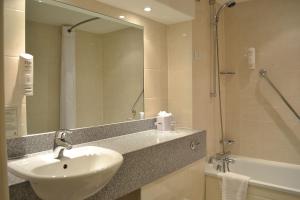 a bathroom with a sink and a mirror and a shower at Coventry Hotel By Belvilla near City Centre in Coventry +25 photos