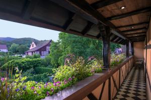 a balcony with flowers and a view of a garden at Le B. VINTAGE in Riquewihr
