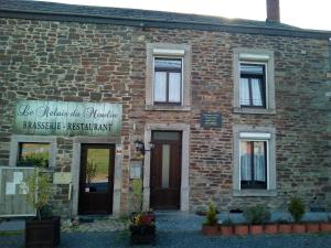 a brick building with a sign on the front of it at Le Relais du Moulin in Gedinne