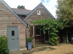 uma casa com uma porta branca e uma árvore em The Annex at Meadow Farm em Cambridge