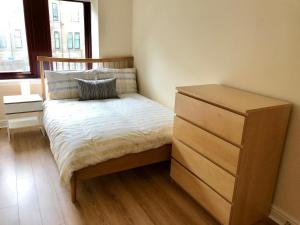 a small bedroom with a bed and a dresser at The Murano in Glasgow