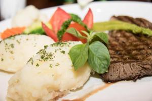 a plate of food with meat and vegetables on it at Lewiinski's Hotel in Pattaya