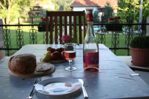 a table with a bottle of wine and a plate of food at Börzsöny Apartman in Kóspallag